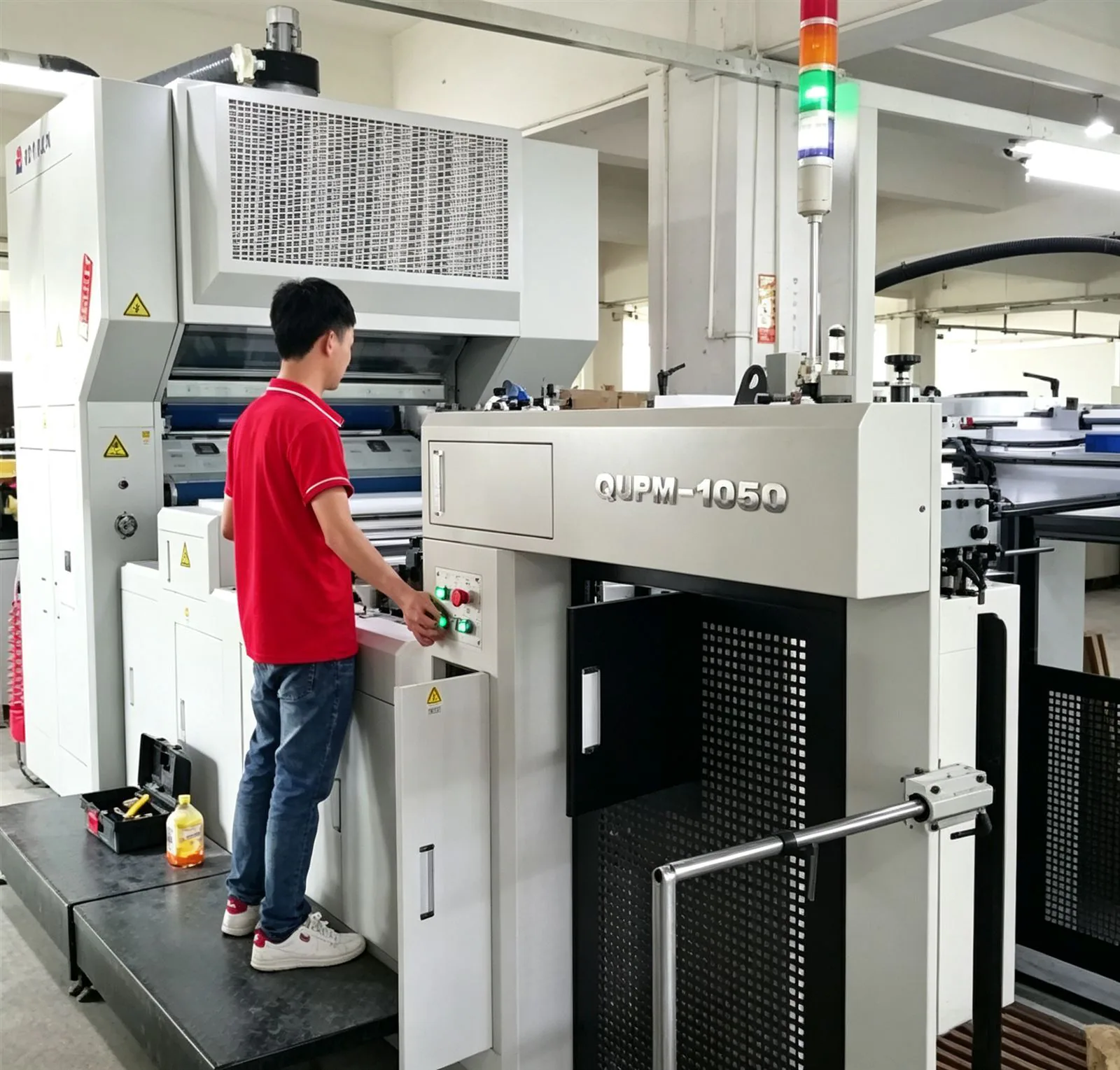 A die-cut operator running a corrugated blank on the factory line, cutting clean parts for custom cat furniture.