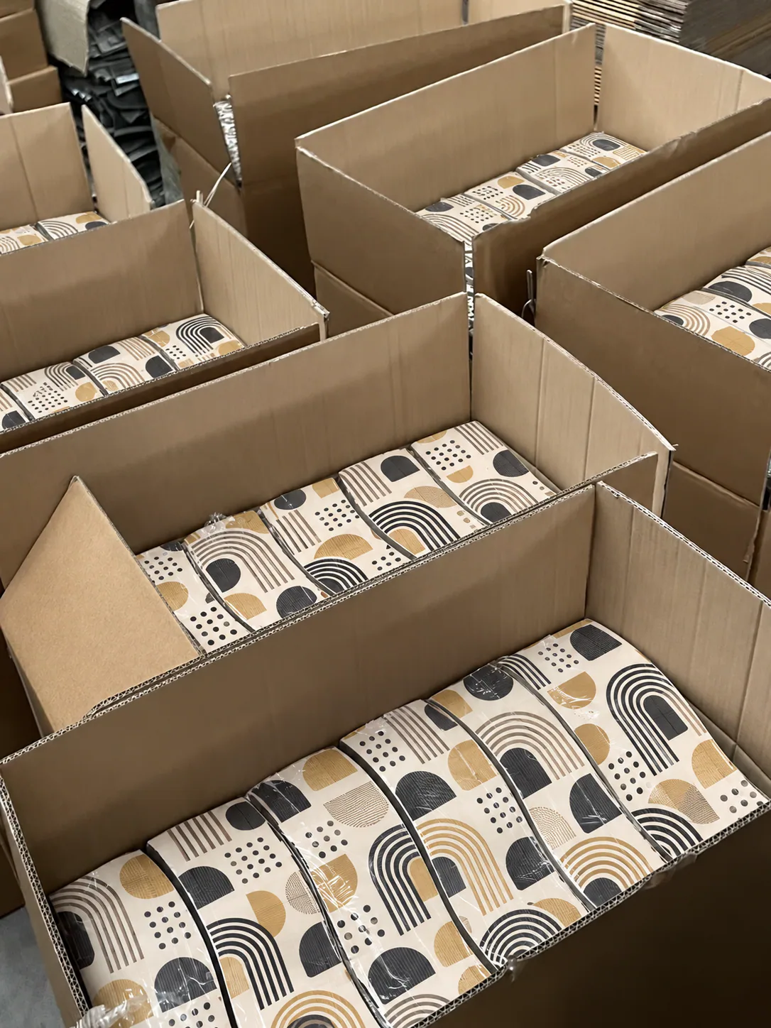 Patterned scratchers nested in shipping cartons, print protected and counted for dispatch.