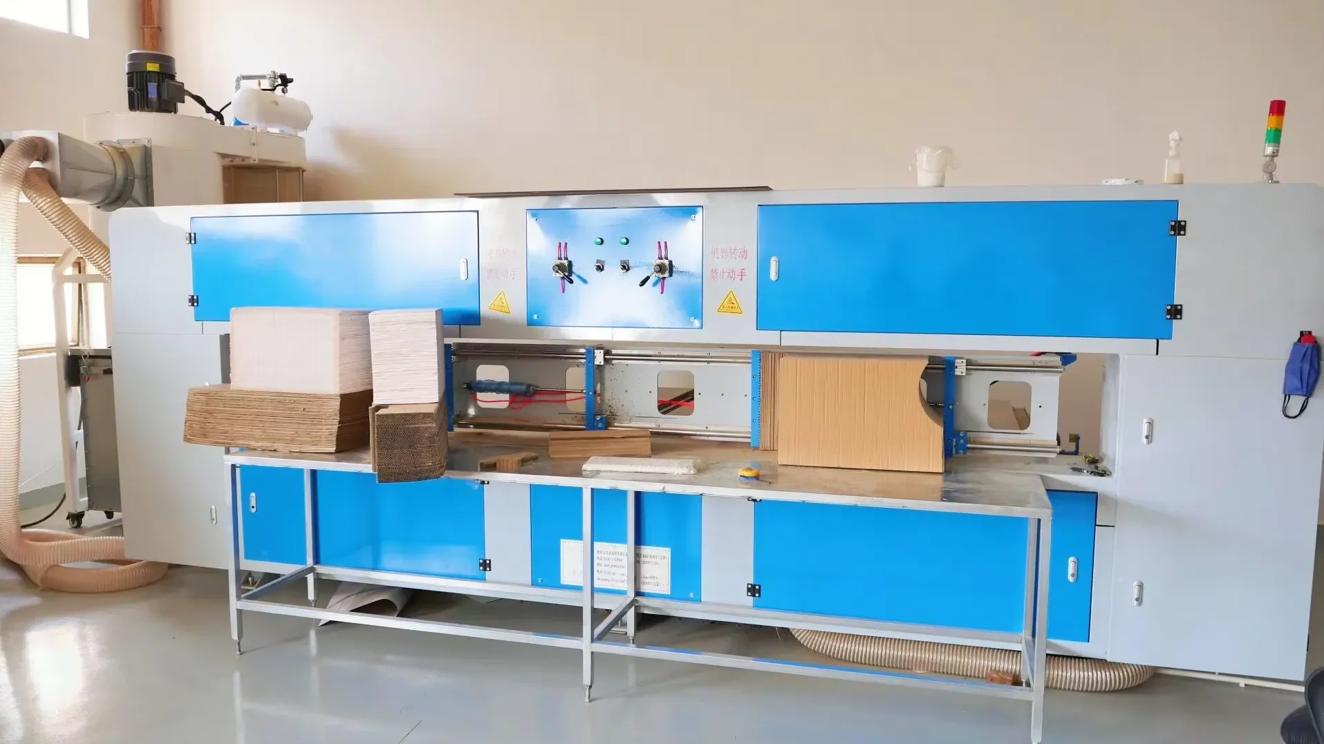 A wide automatic die cutter with feed tables, handling full sheets for lounge and house parts.