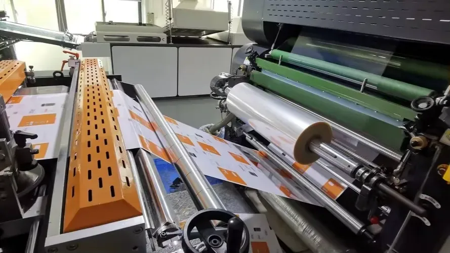 Film being laid onto a printed sheet for a cleaner surface and sharper cat artwork.