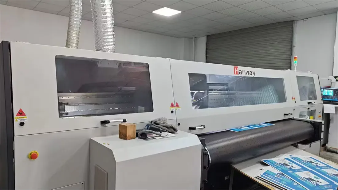 Laminator running a printed scratcher sheet, locking the artwork onto the corrugated core.