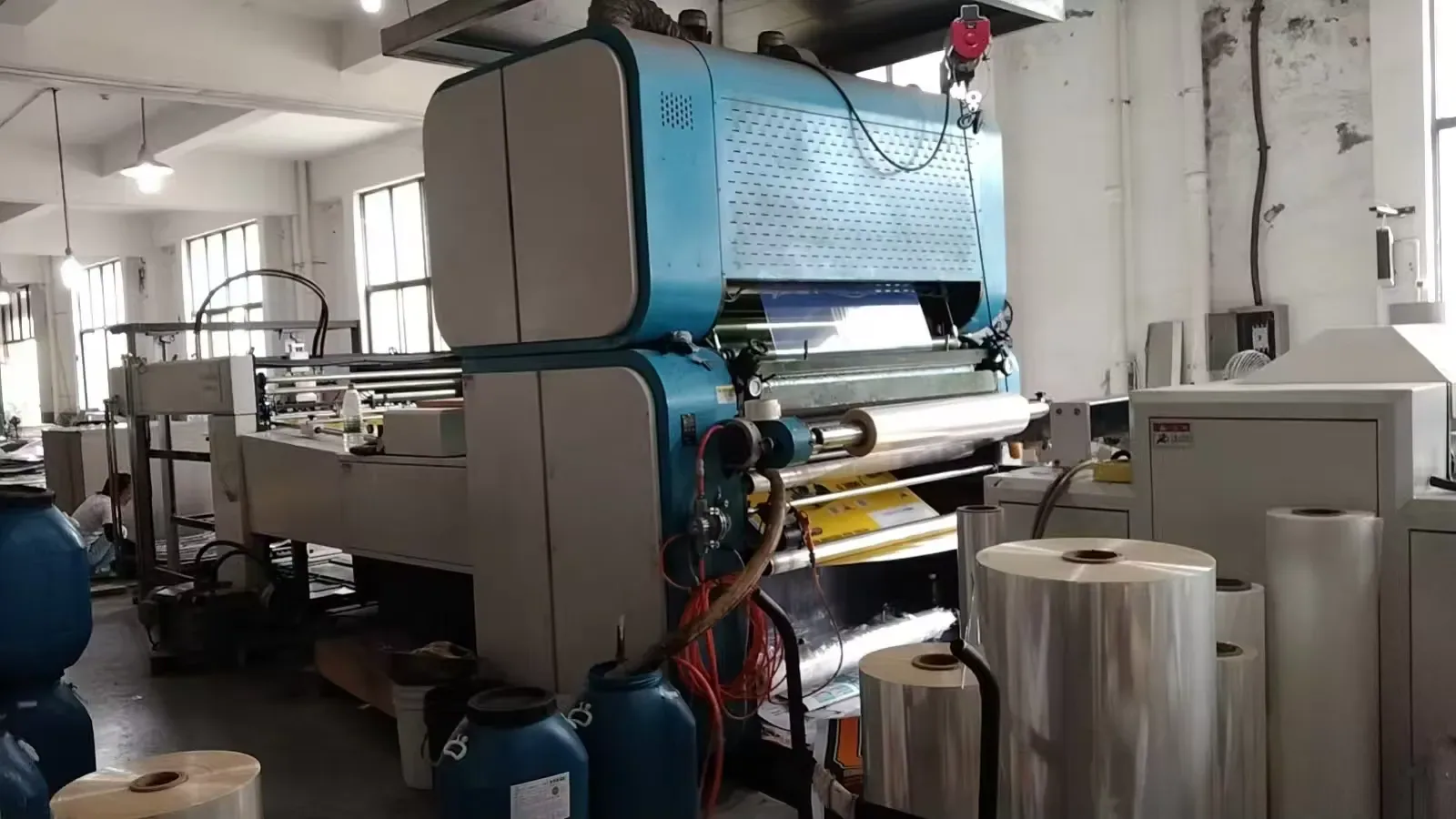 Laminator with a film roll ready to lay a smooth face over corrugated board.