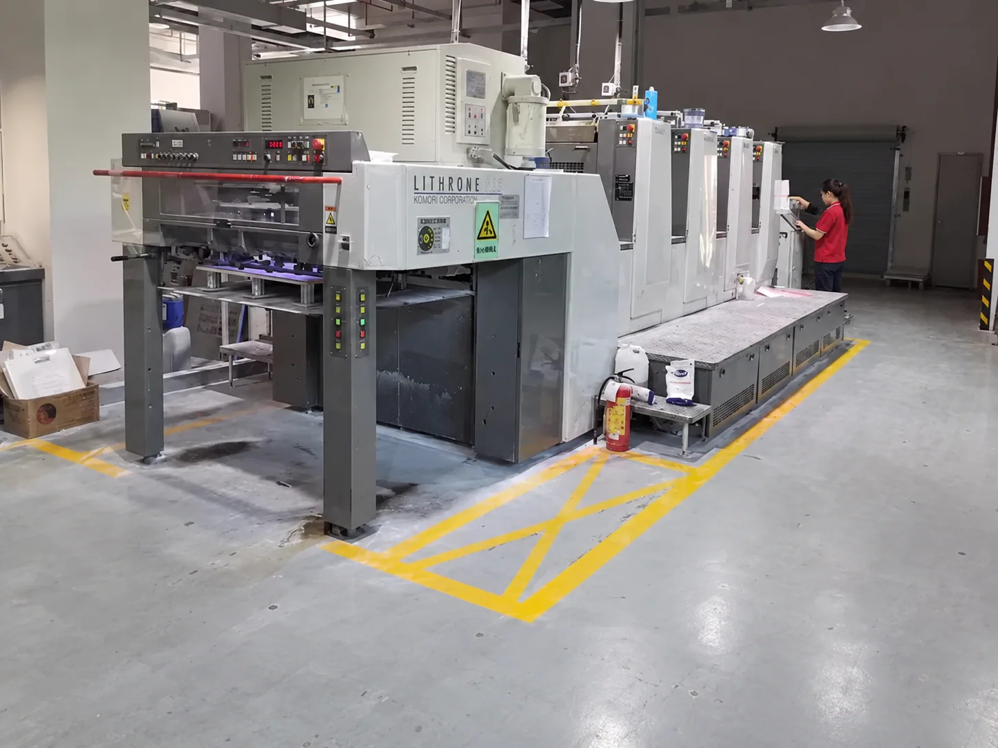 A full-color offset press on the factory floor, set up for sharp retail print on corrugated cat furniture.