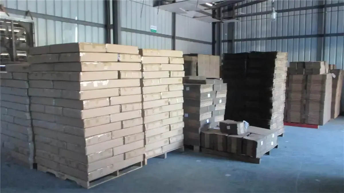 Sheet pallets waiting under the warehouse roof, buffered for the next die-cut and print schedule.